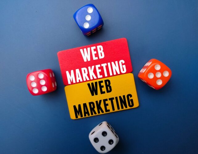 Colored board and dice with the word WEB MARKETING. Business concept